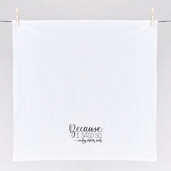 White floursack towel with black hand lettered illustrated design that says Because I said so - every mom ever shown unfolded and hanging from clothes pins