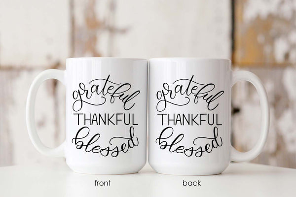 15oz white ceramic mug with hand lettered illustrated design that says Grateful Thankful Blessed showing both front and back of the mug