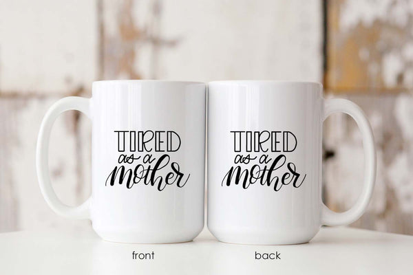15oz white ceramic mug with hand lettered illustrated design that says tired as a mother showing both front and back of the mug