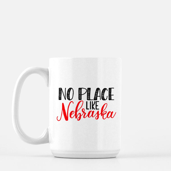 15oz white ceramic mug with hand lettered illustrated design that says No Place Like Nebraska