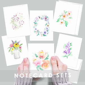 set of 6 watercolor floral notecards shown laid out and a set tied with a jute string held by a hand
