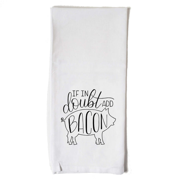 White floursack kitchen towel with black hand lettered illustrated design that says If in doubt add bacon with a outline of a pig