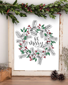 Wall art that says be merry in black with wreath of evergreen berries and leaves surrounding words