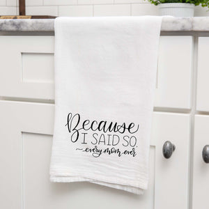 White floursack towel with black hand lettered illustrated design that says Because I said so - every mom ever shown folded and hanging from a countertop in a modern kitchen