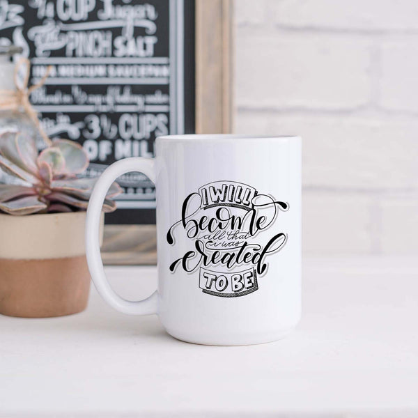 15oz white ceramic mug with hand lettered illustrated design that says I will become all that I was created to be shown in a kitchen with a plant and decorative sign