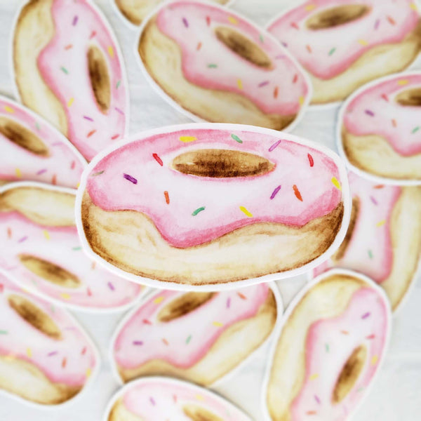 3" vinyl watercolor sticker of a a round donut with pink frosting and rainbow sprinkles