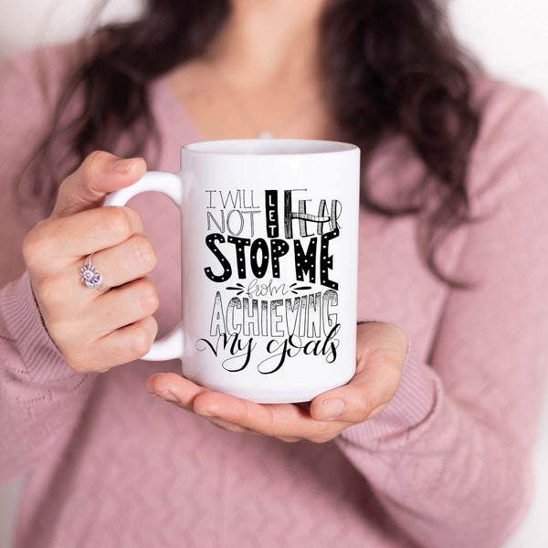 15oz white ceramic mug with hand lettered illustrated design that says I will not let fear stop me from achieving my goals shown with a woman holding the mug