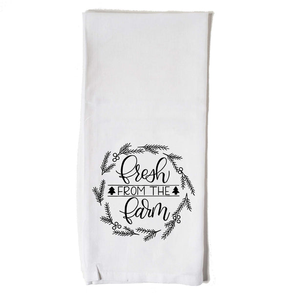 White Floursack Kitchen towel with black hand illustrated design that says fresh from the farm with twigs and berries in a wreath shape 