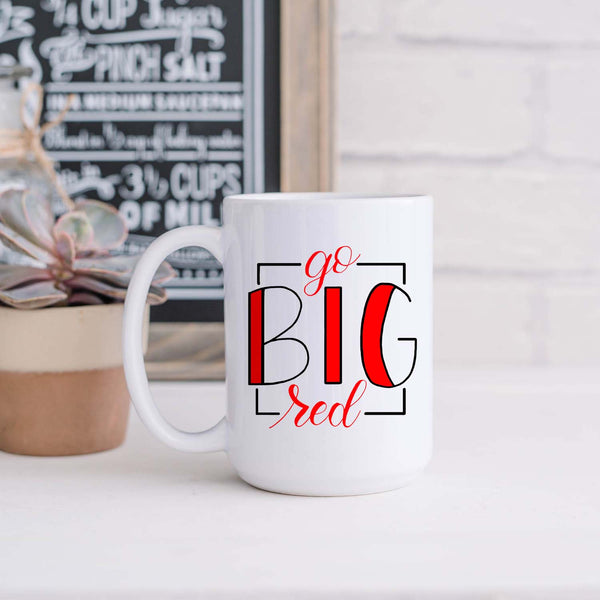 15oz white ceramic mug with hand lettered illustrated design that says Go Big Red shown sitting in a kitchen