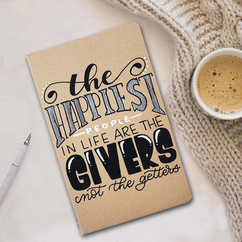 Hand painted gift giving/tracking journal that says the happiest people in life are the givers not the getters shown with a cozy sweater, coffee and pen