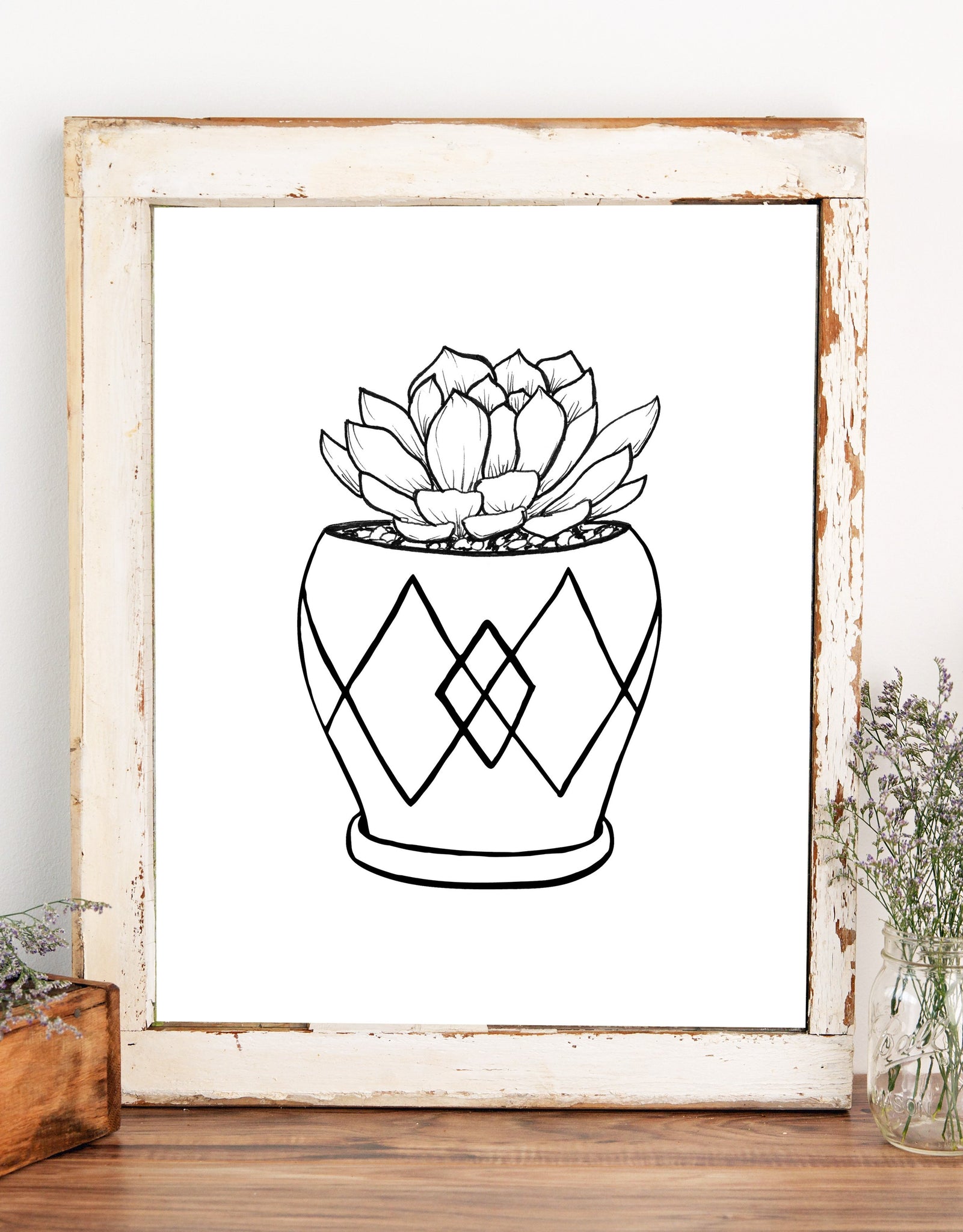 Wall art illustration of a hen and chick succulent in a mod style pot with diamond patterns in black and white shown in a wood frame with white chippy paint and a glass jar of flowers.