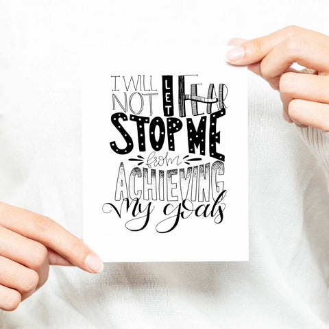 I will not let fear stop me from achieving my goals hand lettered black and white greeting card on a white folded card with A2 envelope shown with a woman in a white sweater holding card