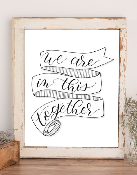 wall art that says we are in this together inside a folding ribbon illustration