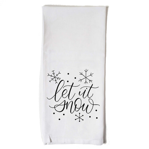 White Floursack Kitchen Towel with black hand lettered illustration that says let it snow with snowflake doodles