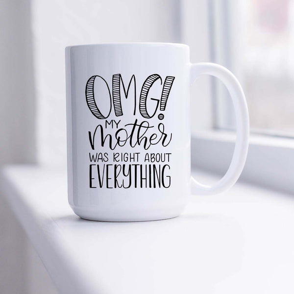 15oz white ceramic mug with hand lettered illustrated design that says OMG! My mother was right about everything shown sitting in a sunny window