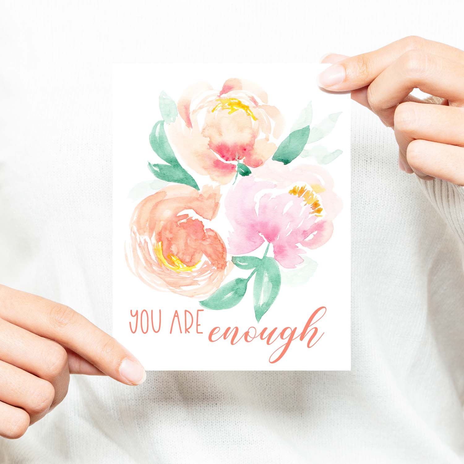 watercolor peonies in soft pastel colors friendship greeting card that says you are enough with a white A2 envelope shown with a woman in a white sweater holding card