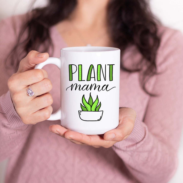 15oz white ceramic mug with hand lettered illustrated design that says Plant mama with the illustration of a succulent with green leaves shown with a woman holding the mug