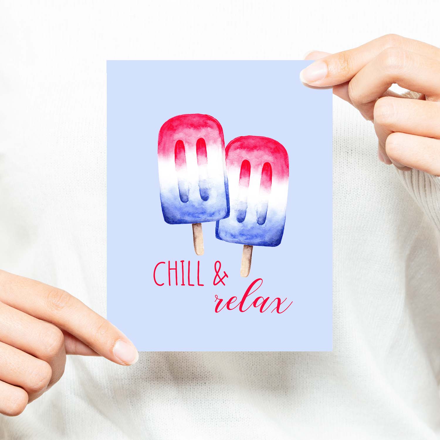 watercolor red white and blue summertime popsicles on a friendship greeting card that says chill & relax with a white A2 envelope shown with a woman in a white sweater holding card
