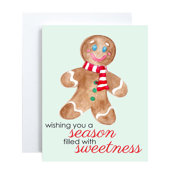 Watercolor Christmas card with a happy watercolor gingerbread man that says wishing you a season filled with sweetness