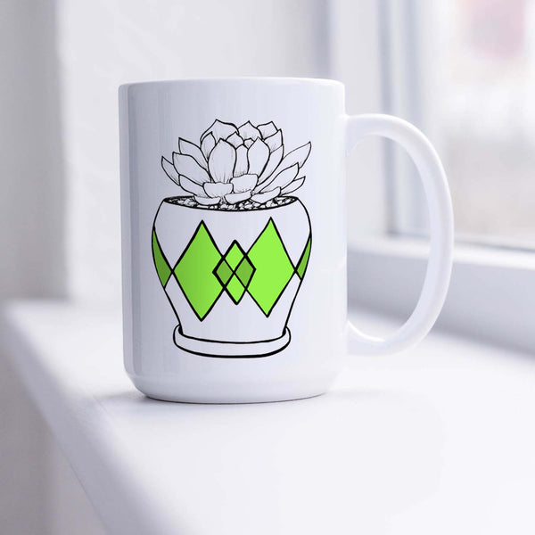 15oz white ceramic mug with hand lettered illustrated design of a succulent plant in a pot with green diamond pattern shown sitting in a sunny window