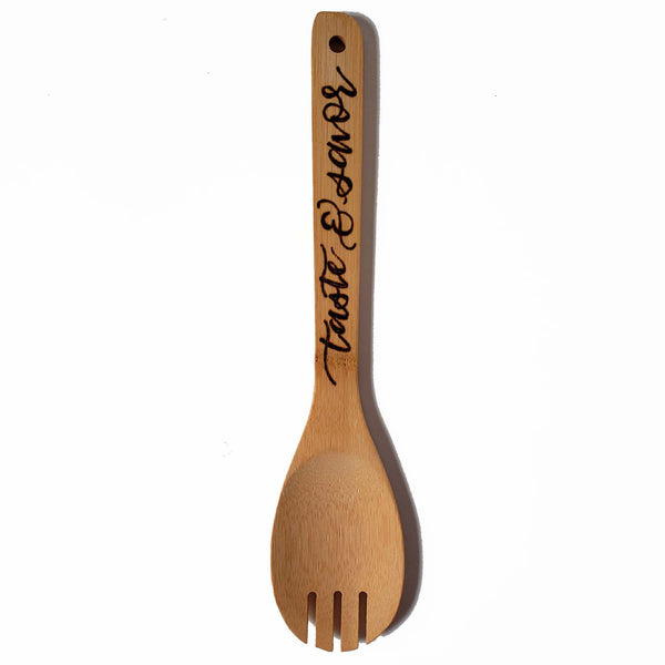 Bamboo round serving fork that says taste & savor in burned hand lettering