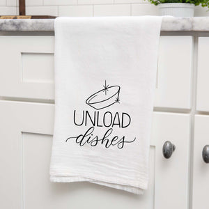 White floursack towel with black hand lettered illustrated design that says Unload dishes with a clean bowl doodle shown folded and hanging from a countertop in modern kitchen