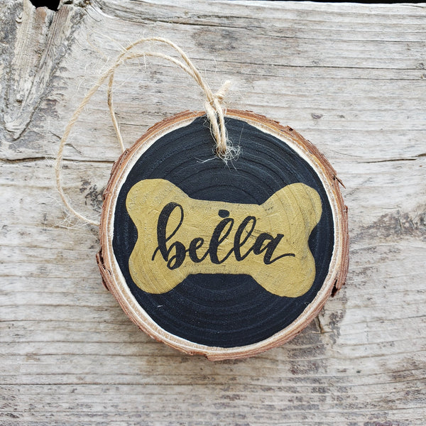 rustic wood slice ornament with hand drawn dog bone with pet name inside in black hand lettering