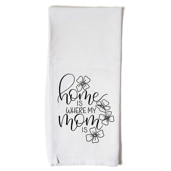 White floursack towel with black hand lettered illustrated design that says home is where my mom is with flower doodles