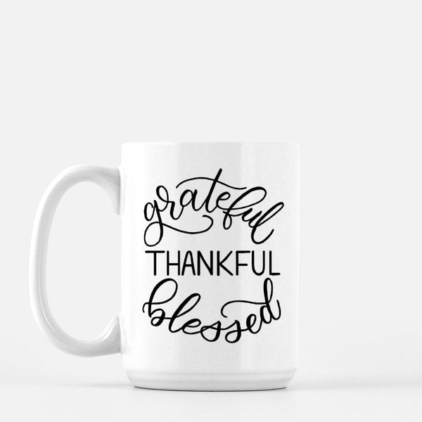 15oz white ceramic mug with hand lettered illustrated design that says Grateful Thankful Blessed